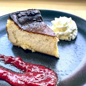 Slice of Burnt Basque Cheesecake with House Made Jam and Whipped Cream. **contains wheat, dairy, egg**