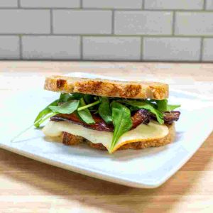 Egg, Bacon, Muenster Cheese, Avocado Spread, Chili Flakes on Looks Sourdough Bread.
