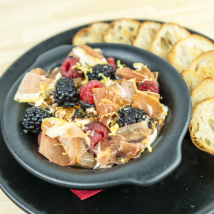Creamy artisan burrata, with serrano ham, fresh raspberries, blackberries, bright lemon zest, apple saba drizzle, served with toasted crostini.
